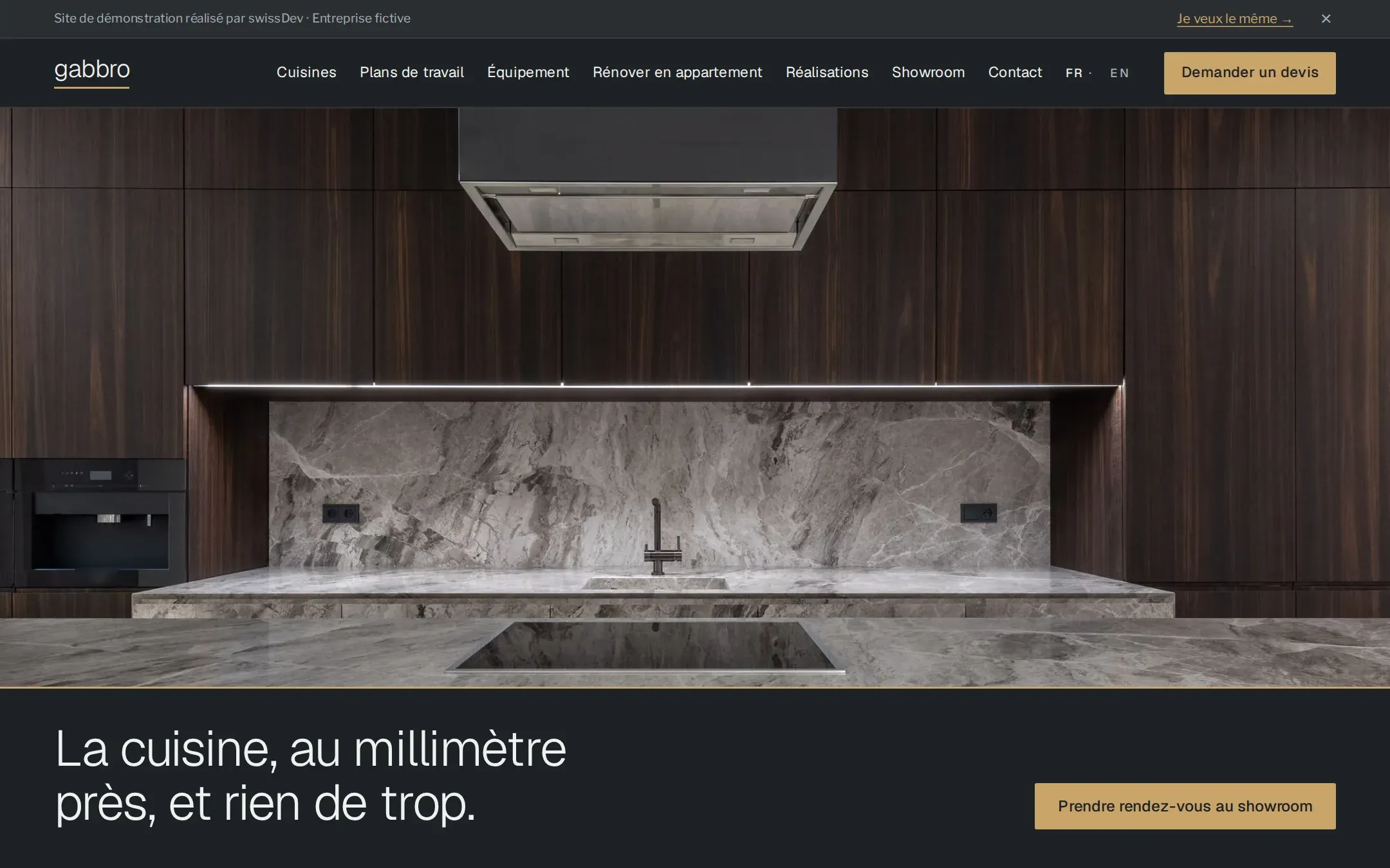Page d’accueil de Gabbro, une cuisine sombre en plein écran posée sur une bande gris-noir à arête de laiton qui porte le titre et le bouton du showroom